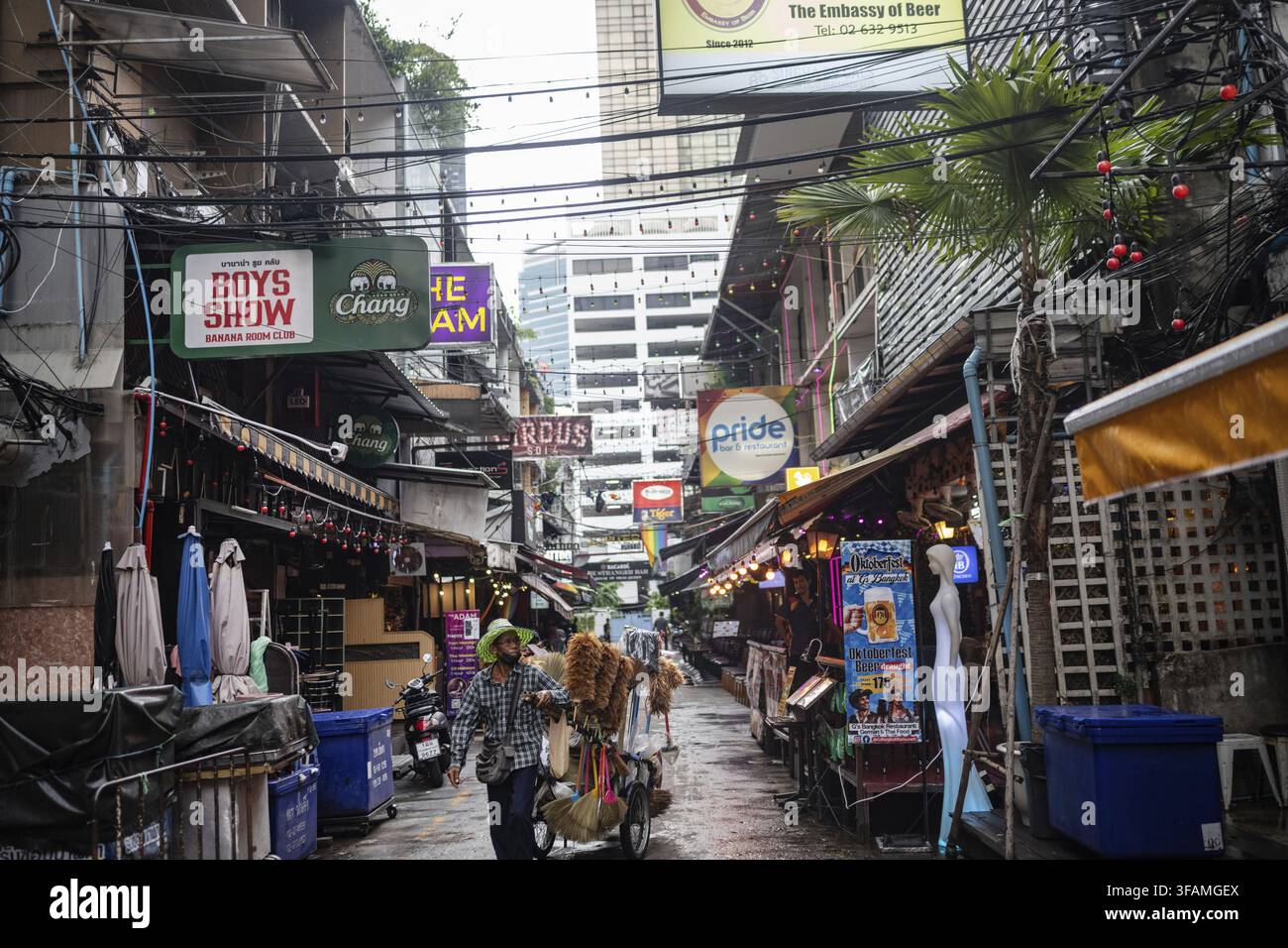Bangkok, Thailandia. 18 agosto 2026. Un uomo spinge un carrello che vende spazzole e scope attraverso il distretto del mercato notturno di Patpong vicino alla strada Silom nel centro Foto Stock