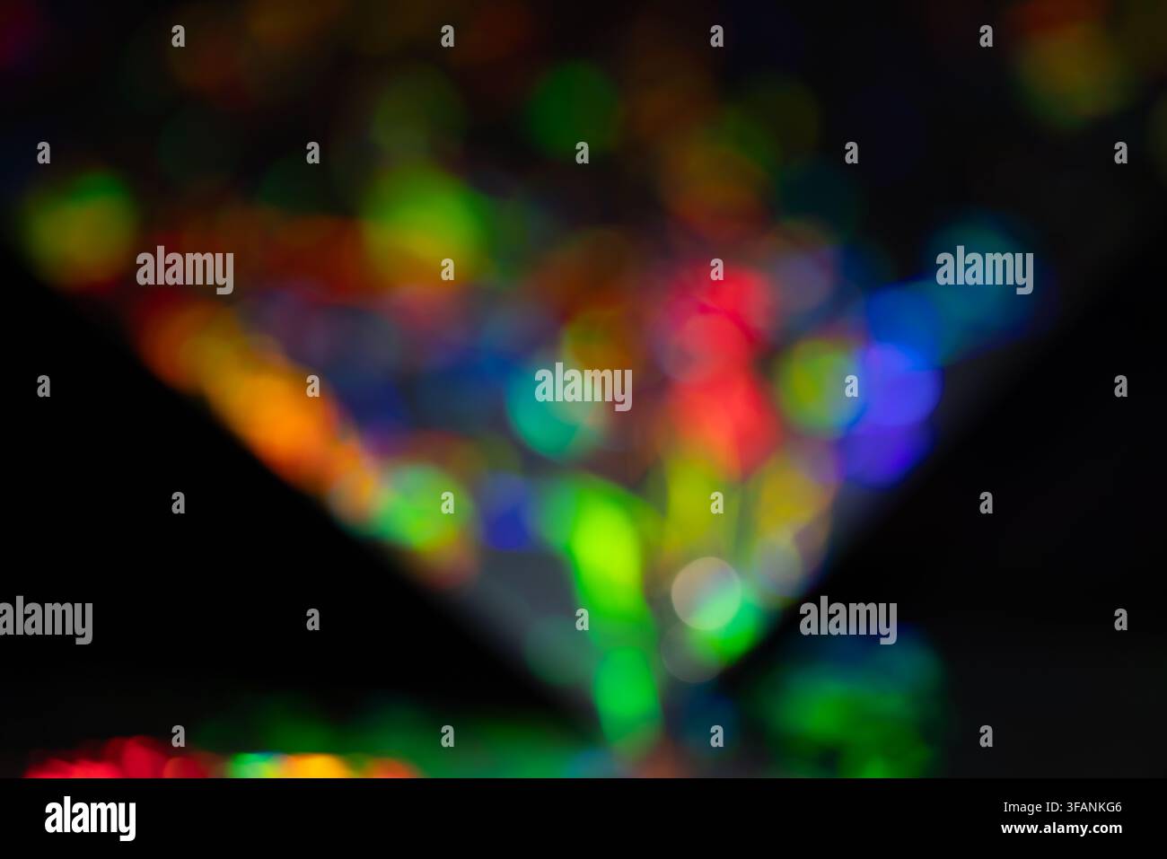 Bokeh triangolare astratto arcobaleno e riflessi di prismi su sfondo scuro per banner per feste o design grafico creativo Foto Stock