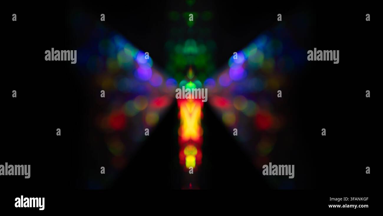 Bokeh arcobaleno simmetrico a forma di farfalla su sfondo nero per feste di vacanza astratte o design creativo Foto Stock