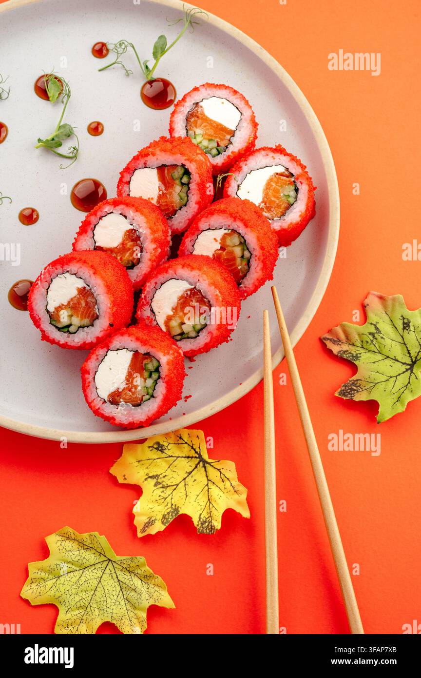 Rolls California con tobiko rosso e bacchette Foto Stock