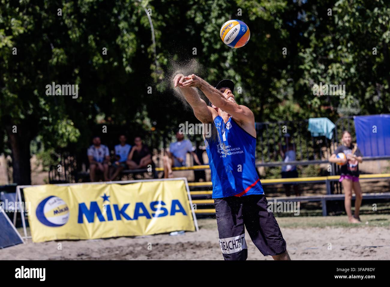 Atleta maschio lancia la palla giocando a beach volley Foto Stock