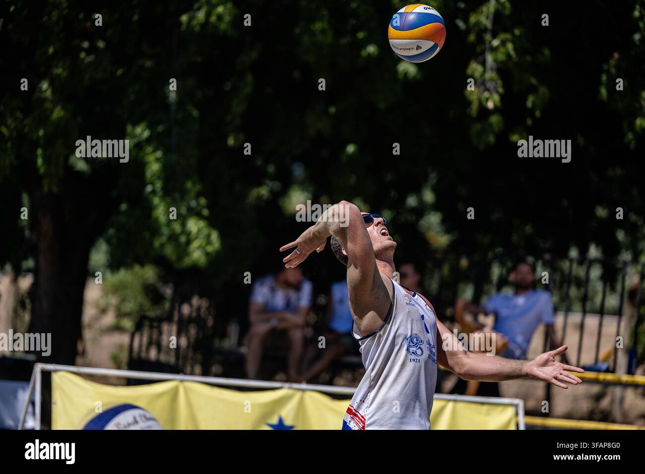 Giocatore di beach volley maschio che serve la palla Foto Stock