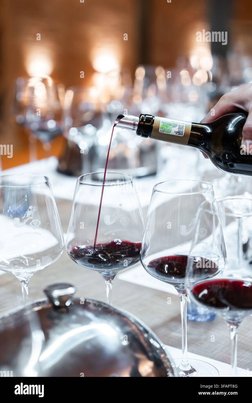 Vino rosso versato nei bicchieri durante una sessione di degustazione Foto Stock