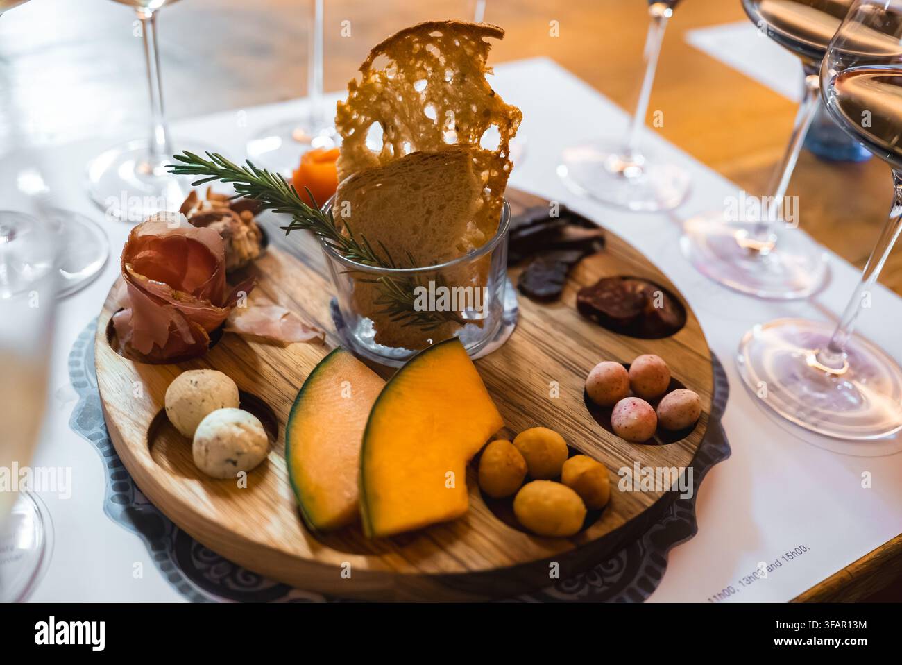 Un vassoio di cibo gourmet accompagnato da bicchieri di vino in una cantina Foto Stock