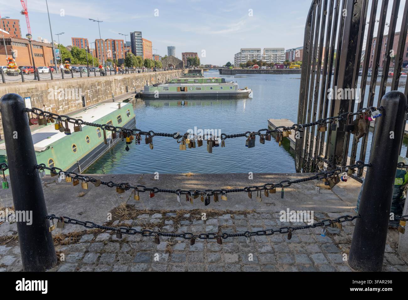 Lucchetti dell'amore attaccati a catene di ferro che si affacciano sulle chiatte e le barche strette del lungofiume di Canning Dock. Foto Stock