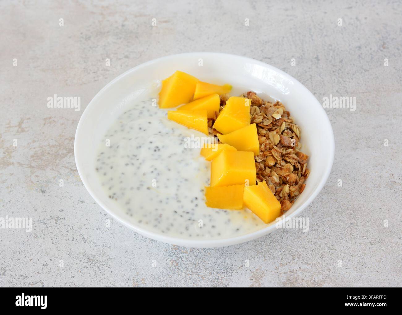 Ciotola di budino di chia salutare con mango fresco e muesli ritagliato Foto Stock