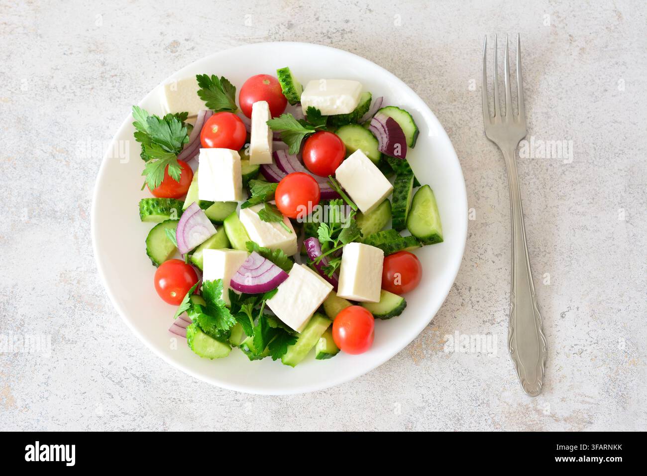 un piatto di insalata fresca con feta, mini pomodorini e cetrioli natura morta Foto Stock
