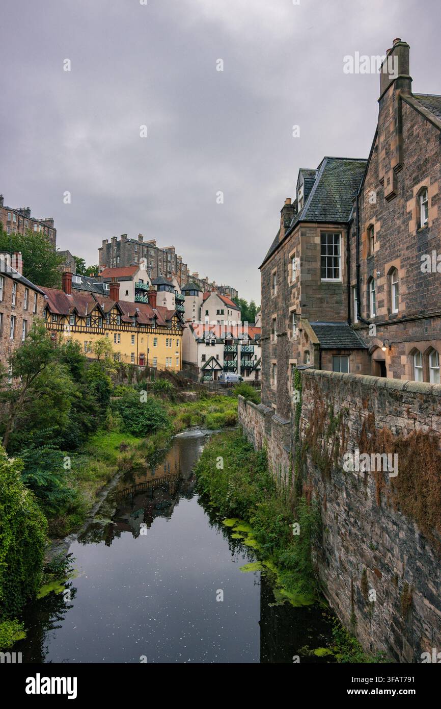 Pittoresche case storiche in pietra di Dean Village lungo il tranquillo fiume Water of Leith a Edimburgo, Scozia Foto Stock