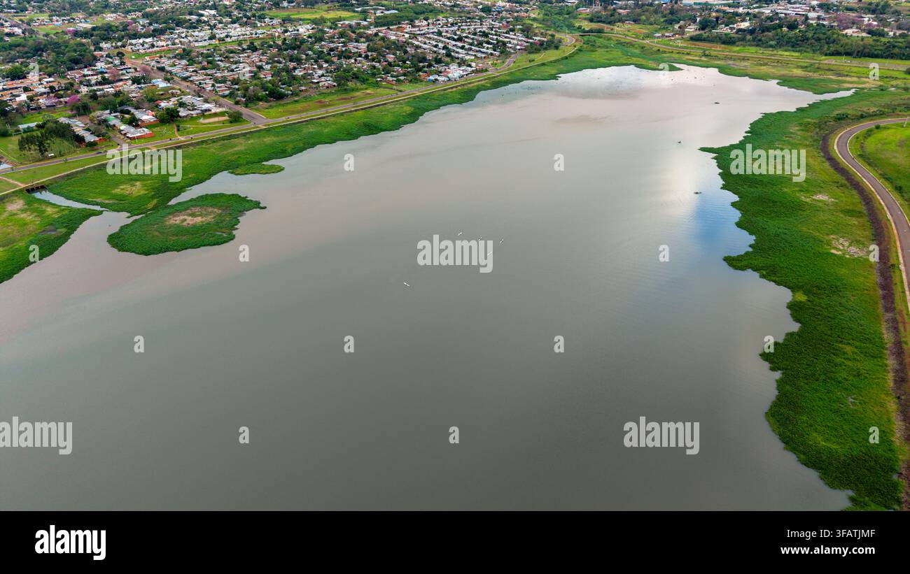 Vista aerea dell'Arroyo Martires che mostra il corso d'acqua circondato da una vegetazione rigogliosa e zone residenziali urbane a Posadas, provincia di Misiones, Arg Foto Stock