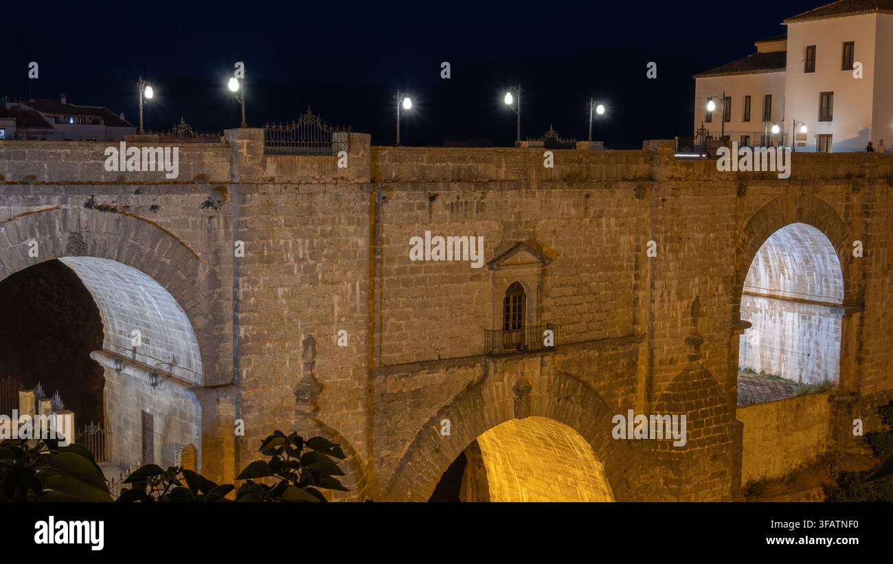 Fotografia notturna del famoso ponte di pietra di Ronda, illuminato di notte, Spagna Foto Stock