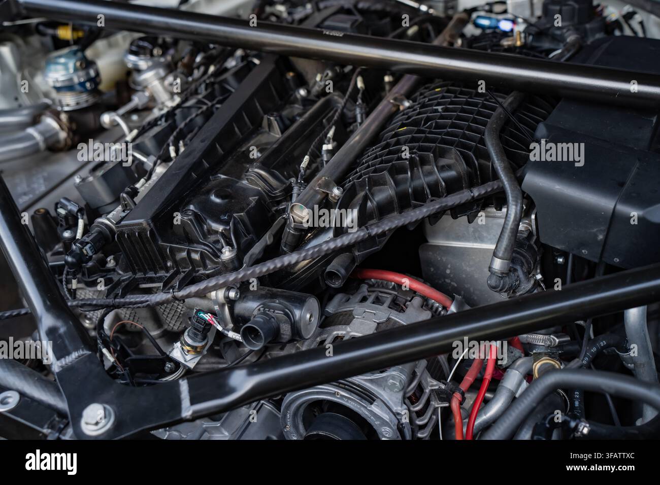 Componenti del motore di un'auto sportiva moderna, incluso il collettore di aspirazione e la barra di rinforzo del telaio Foto Stock
