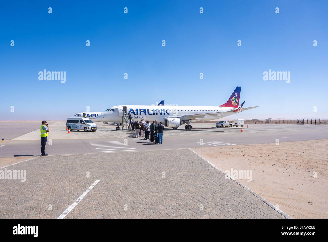 Aereo parcheggiato sulla pista con passeggeri in fase di imbarco sotto il cielo aperto Foto Stock