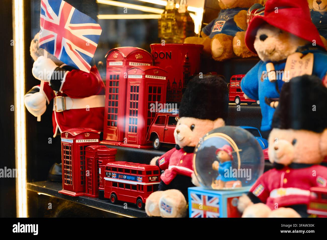 Orsi di peluche, cabine telefoniche rosse in miniatura, bus e bandiere Union Jack esposti nella vetrina di un negozio di souvenir a Londra. Foto Stock