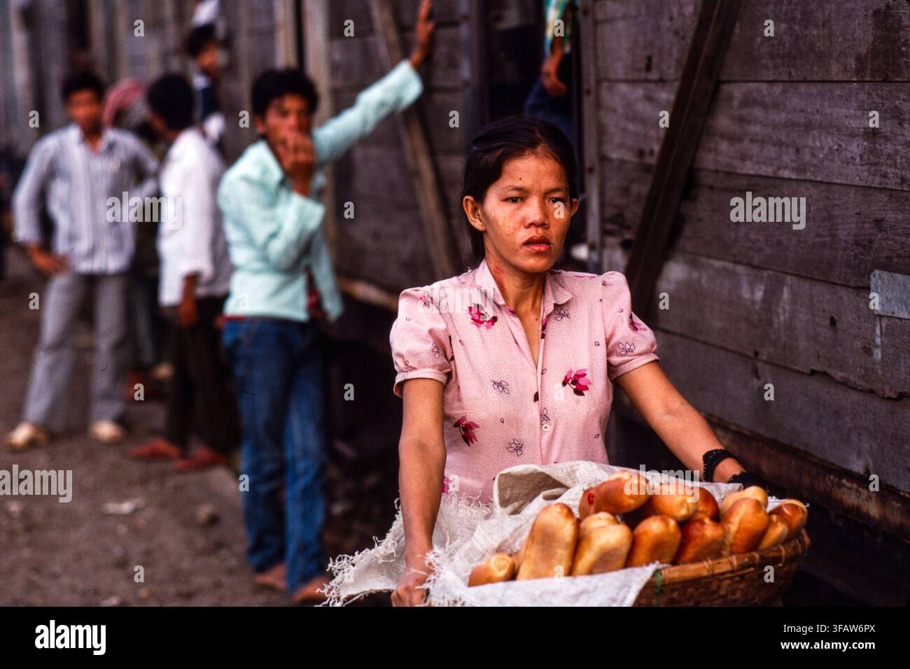Cambogia; i commercianti di strada alla stazione di Phnom Penh vendono cibo per addestrare i passeggeri che stanno per partire per Kompot. 1987 Foto Stock