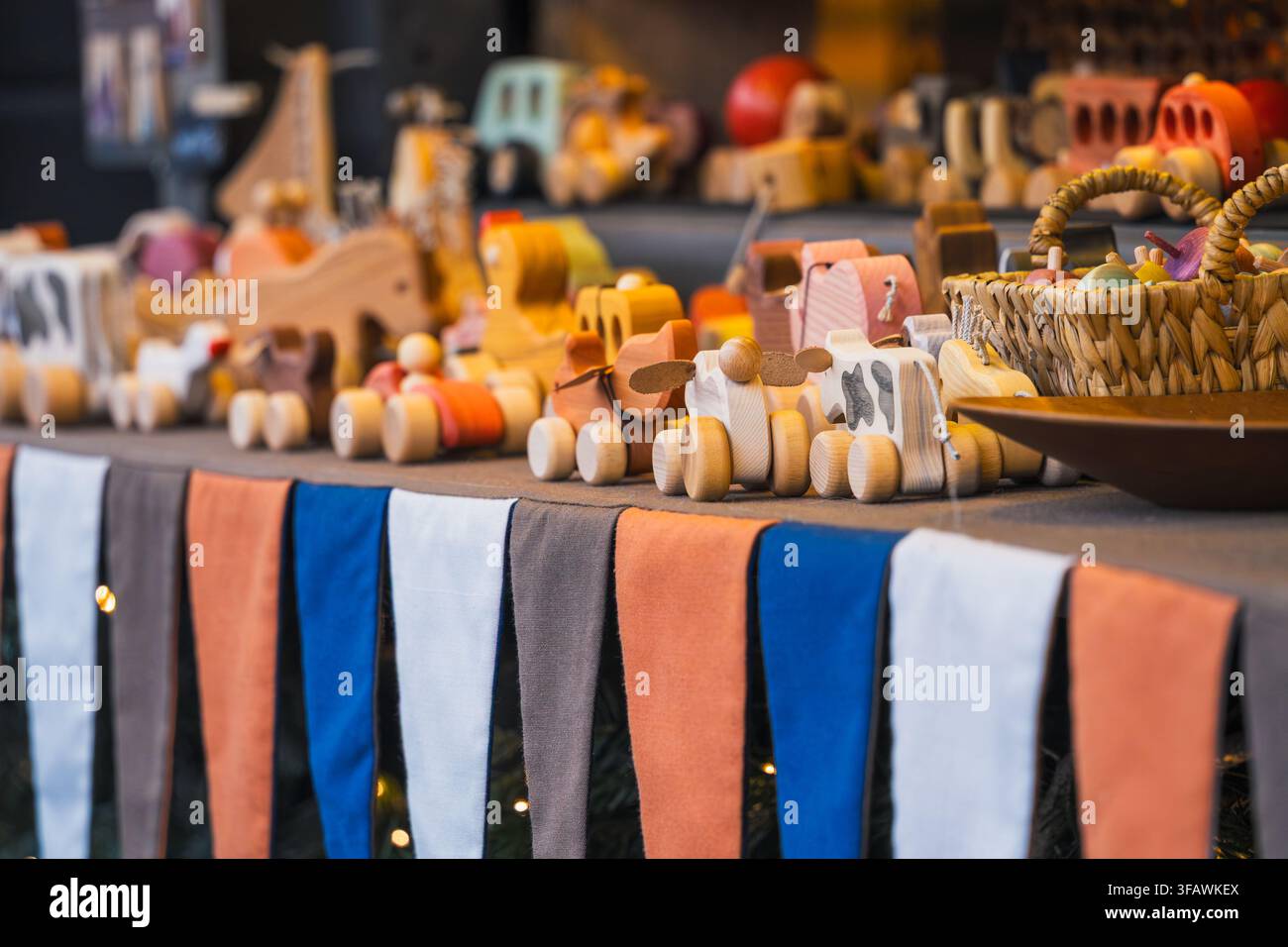 L'artigianato giocoso del legno appare in file di piccoli giocattoli, figurine e oggetti intagliati al mercato natalizio di Riga per la produzione artigianale, regali di famiglia Foto Stock