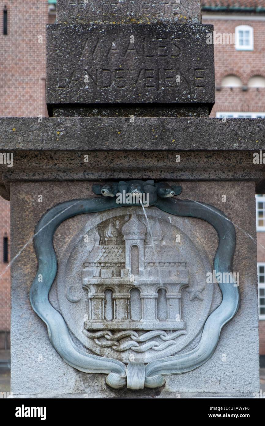 Miliario storico in granito con rilievo scolpito dello stemma a Aalborg, Danimarca, che evoca eredità e orgoglio civico. Foto Stock