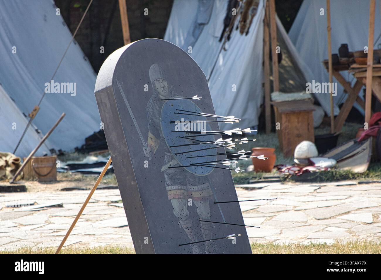 Un bersaglio storico per tiro con l'arco a forma di soldato con molte frecce conficcate nello scudo blu, rievocazione. Foto Stock