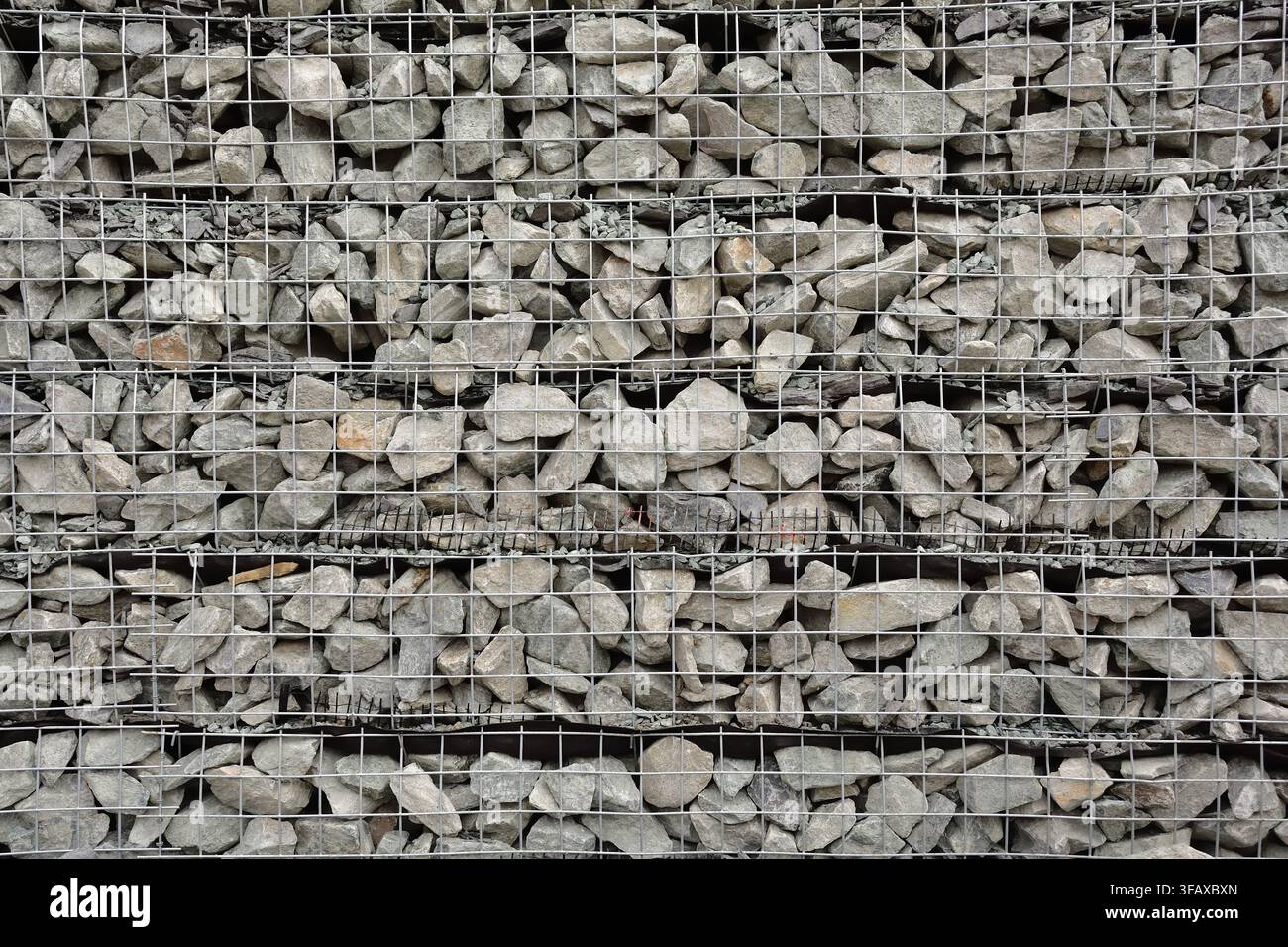 Muro di sostegno in rocce naturali chiamato anche muri a gabioni Foto Stock