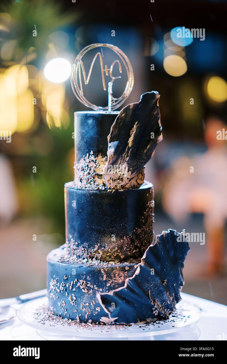 Torta nuziale blu navy a tre piani con decorazioni artistiche Foto Stock