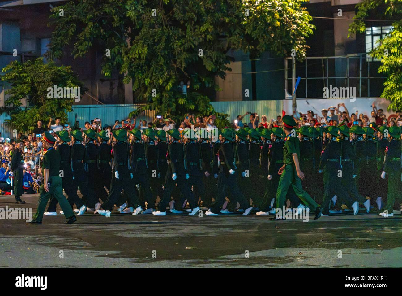 Soldati che marciano in formazione di parata notturna su Van Cao, Hanoi Foto Stock