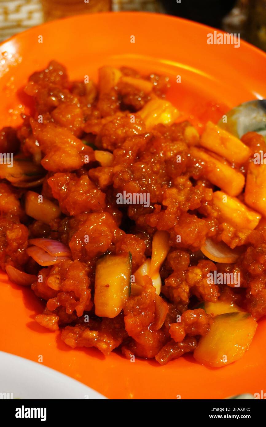 Pollo dolce e aspro con ananas e frutti saltati cibo da ristorante asiatico Foto Stock