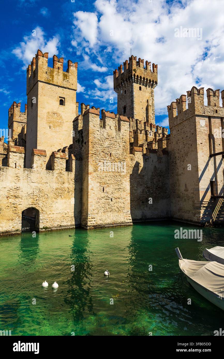 Facciata illuminata dalla luce del sole della Rocca Scaligera di Sirmione dal porto, una fortezza medievale e unico punto di accesso al centro storico della città Foto Stock
