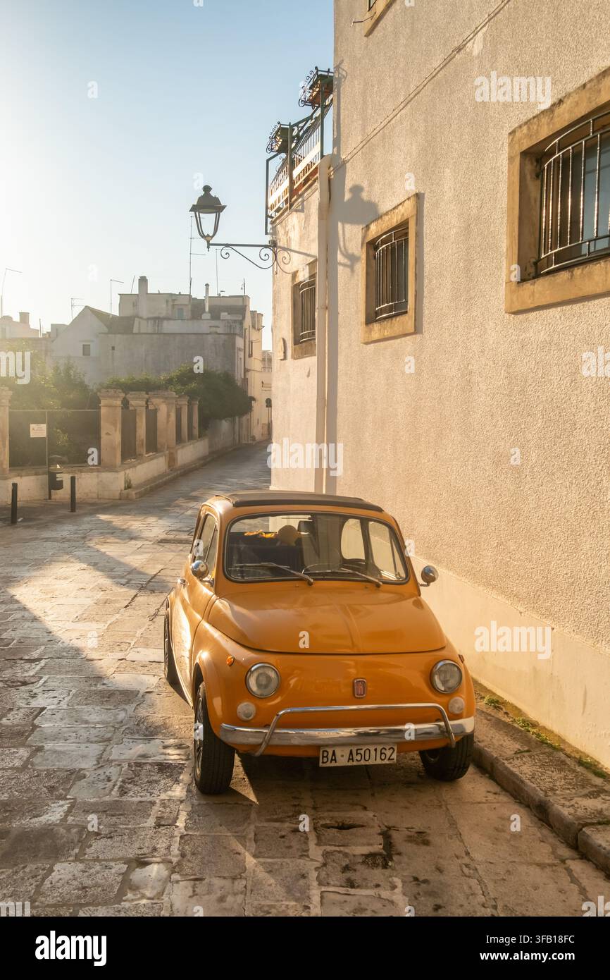 Auto gialla vintage parcheggiata in una strada a Locorotondo, Italia Foto Stock