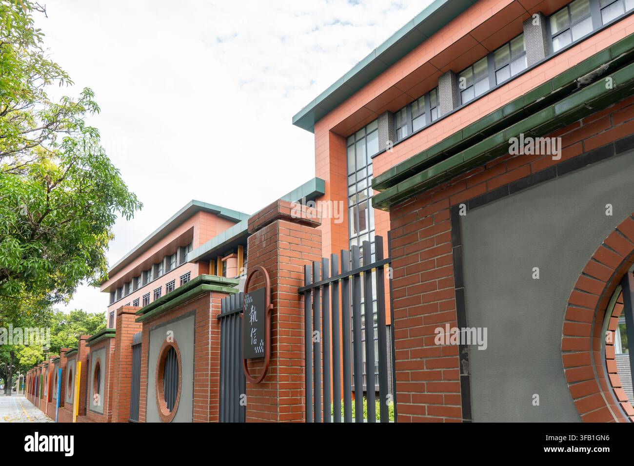 Edificio scolastico moderno in mattoni con finestre circolari. Foto Stock