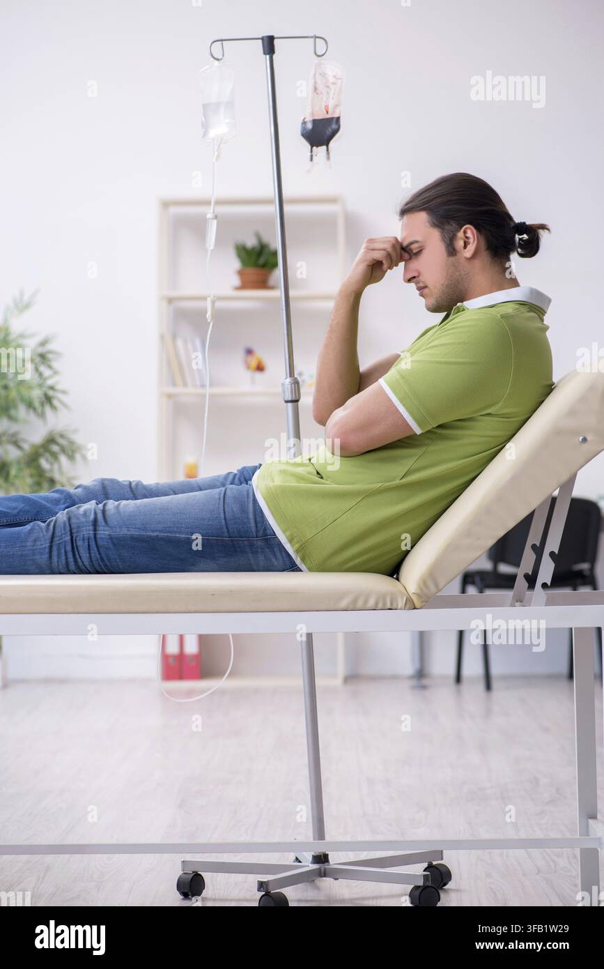 Giovane in attesa del medico in clinica Foto Stock