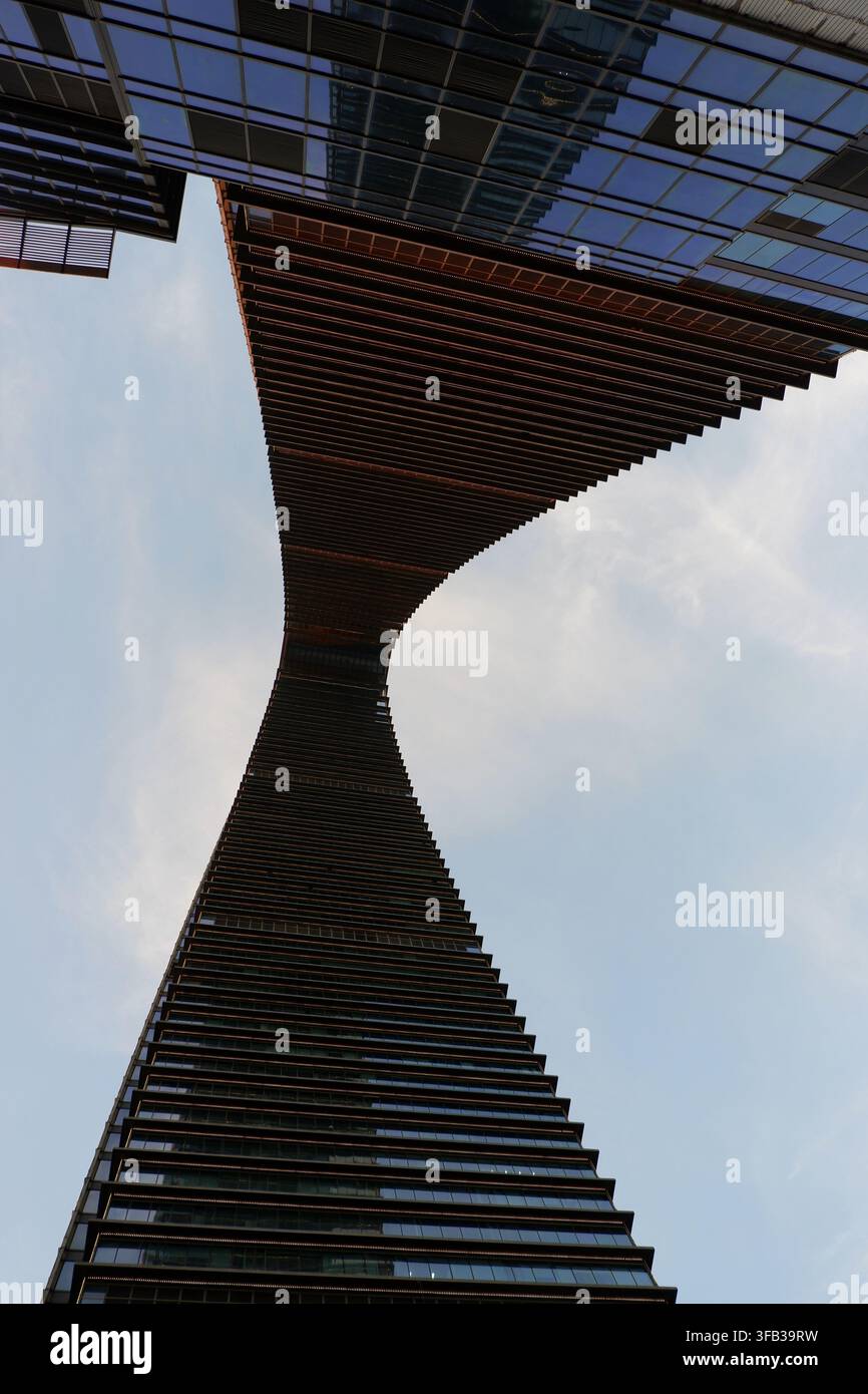 Una vista verso l'alto che cattura la struttura attorcigliata a forma di clessidra del grattacielo Gate of the Orient di Suzhou contro un cielo aperto. Foto Stock