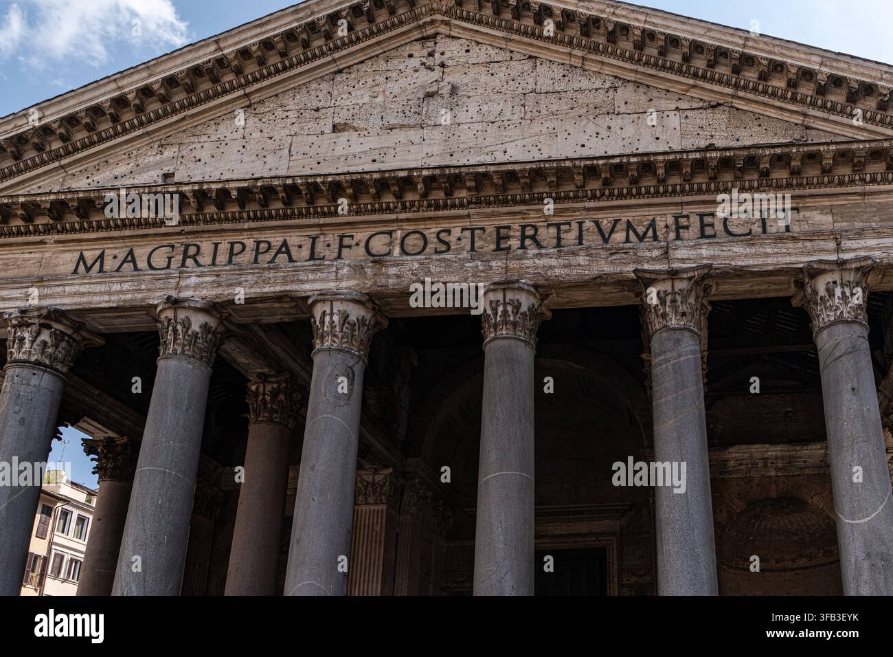Vista ravvicinata della facciata del Pantheon a Roma, Italia, che mostra colonne corinzie erose, iscrizione latina, frontone triangolare e antico monumento monumentale Foto Stock