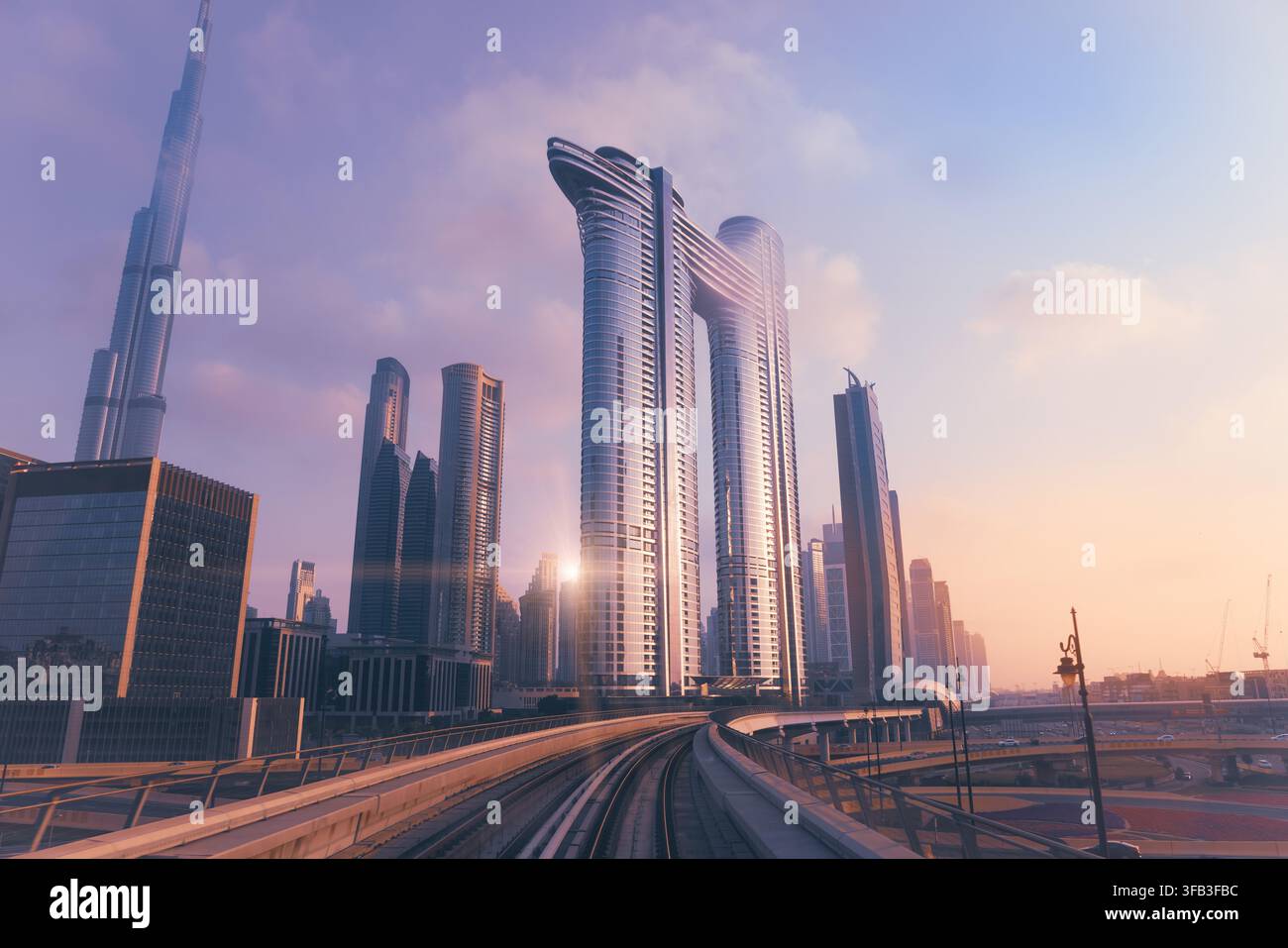Vista panoramica del quartiere degli affari del centro di Dubai negli Emirati Arabi Uniti, con il Burj Khalifa, grattacieli moderni e binari curvi della metropolitana sotto un caldo tramonto Foto Stock