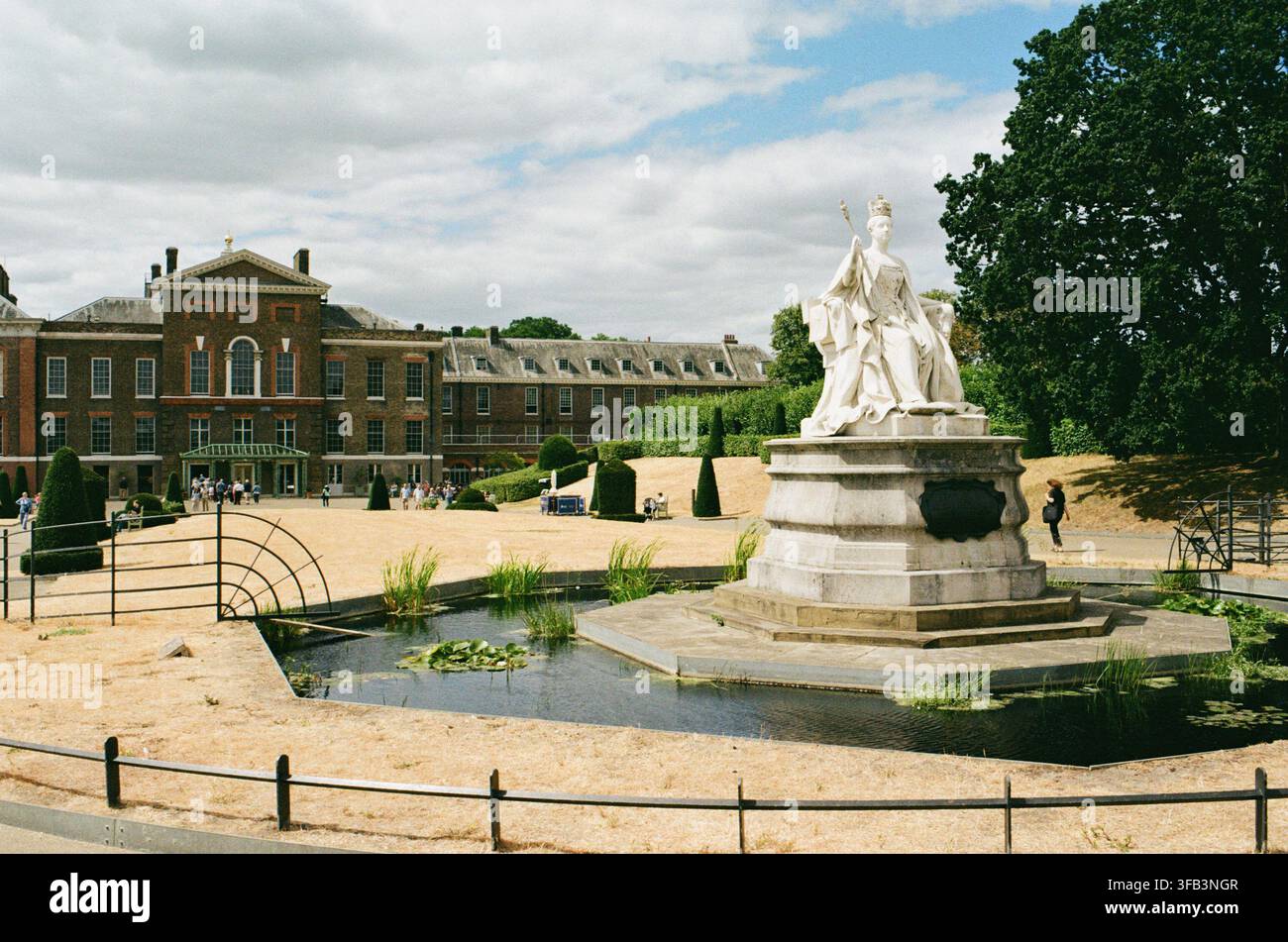 Kensington Palace, Londra UK, durante la siccità estiva dell’agosto 2026, con la statua della regina Vittoria e l’erba secca Foto Stock