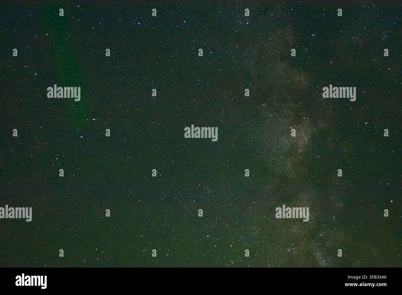 Cielo notturno stellato che mostra la Via Lattea e un raggio laser astronomico verde che punta nello spazio profondo. Foto Stock