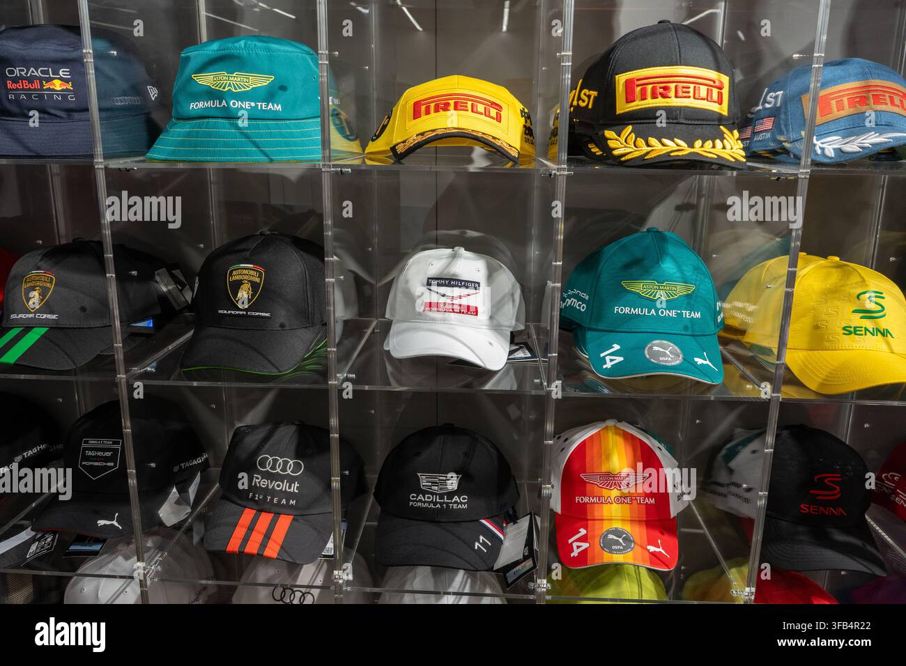 Cappelli da baseball di marca Formula Uno e Motorsport esposti in scaffali acrilici trasparenti. Verona, Italia - 25 giugno 2026 Foto Stock