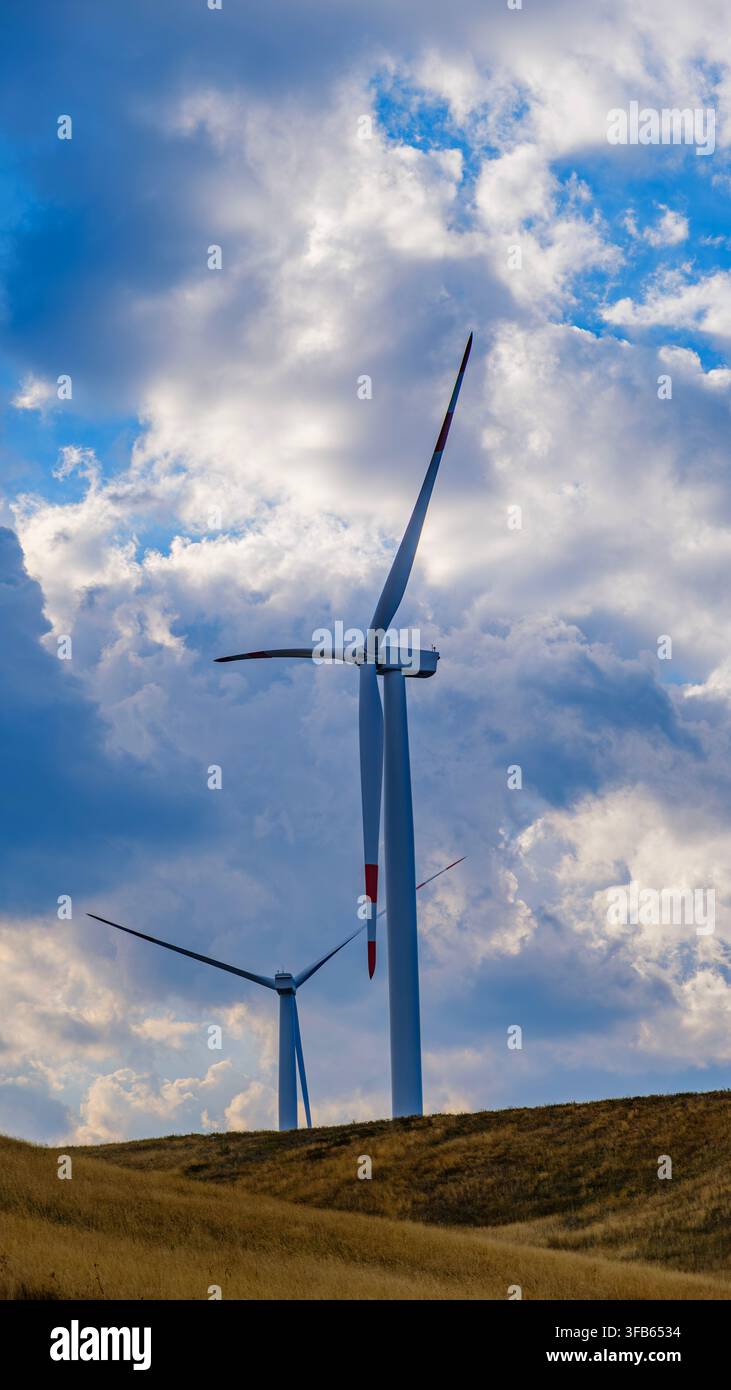 Turbine eoliche su un paesaggio montano, energia rinnovabile, tecnologia pulita, sviluppo sostenibile e la transizione verso un'economia a basse emissioni di carbonio Foto Stock
