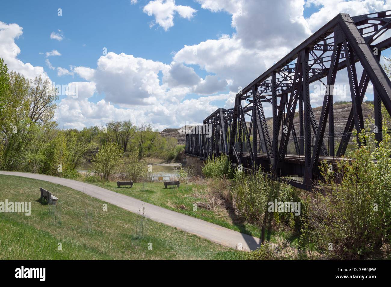 Drumheller, Alberta – Maggio 2026: Ponte a traliccio in acciaio Gordon Taylor che si estende sulla valle del fiume Red Deer sotto un cielo azzurro con soffici nuvole bianche. Foto Stock