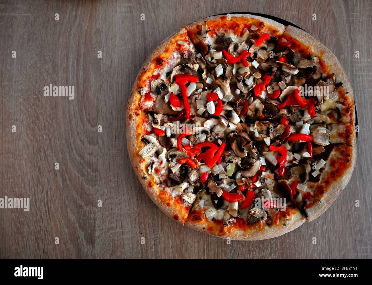 Pizza döner kebab fatta in casa con funghi freschi e peperoni rossi su un tavolo di legno con spazio per il testo. Foto Stock