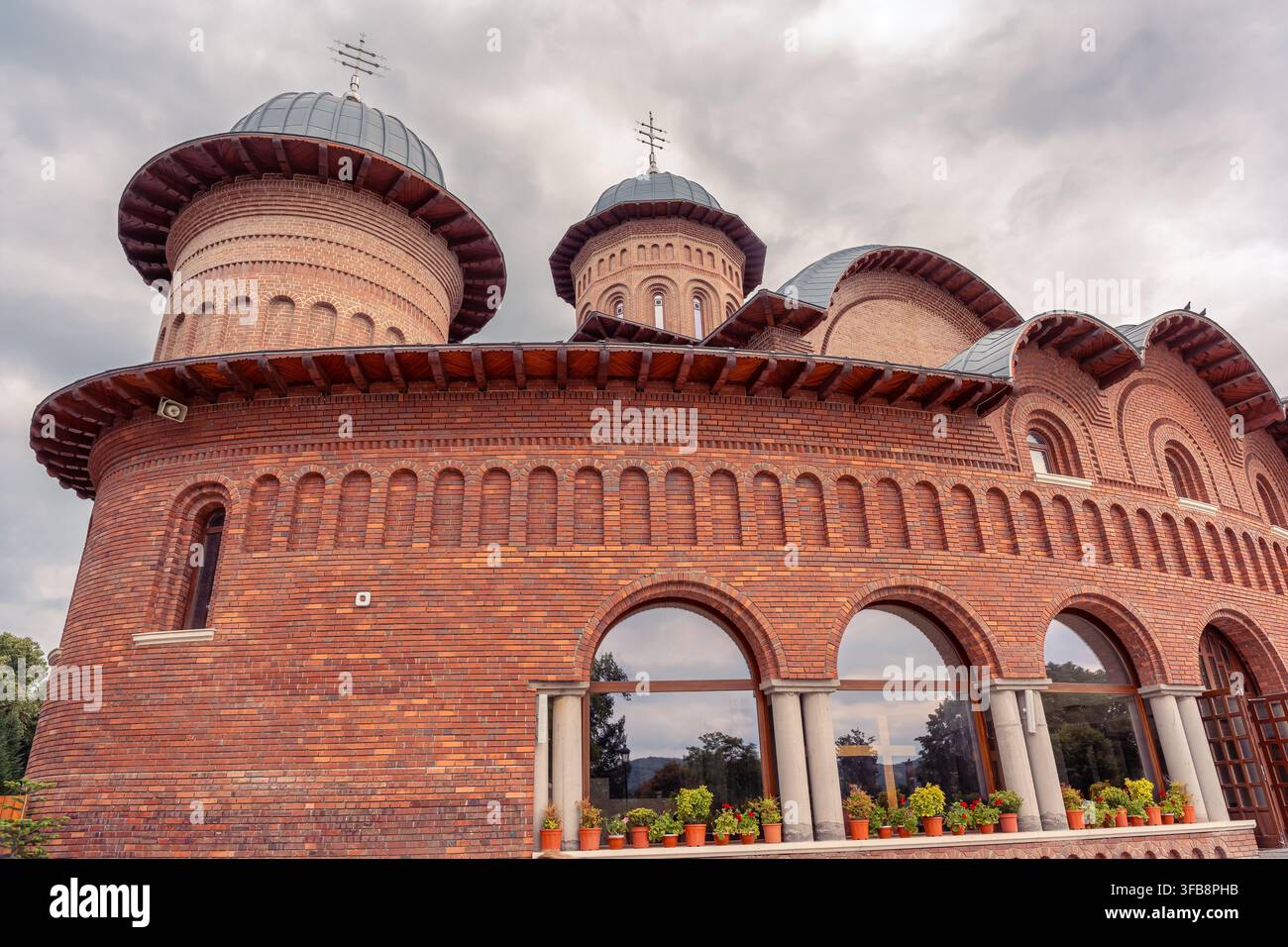 Vista ravvicinata della facciata in mattoni rossi della cattedrale del monastero di Curtea de Argeș nella contea di Argeș, Romania Foto Stock