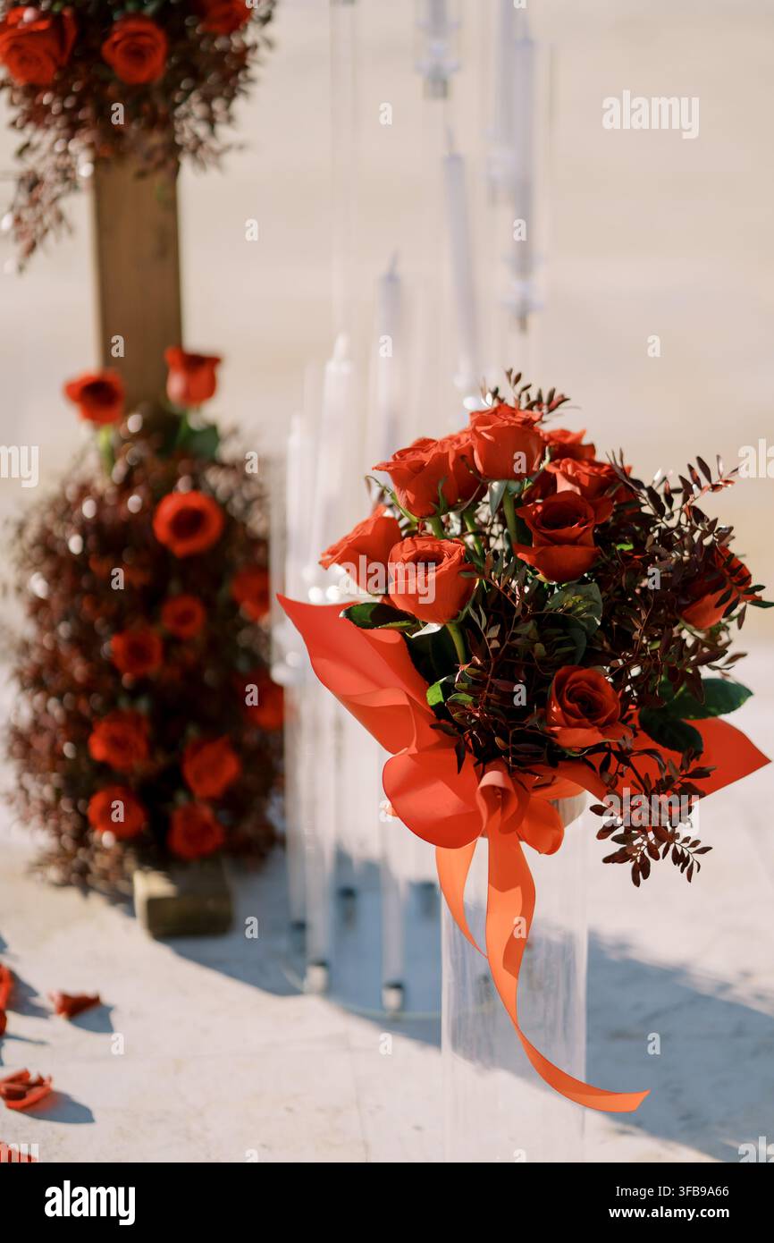 Composizione floreale di rose rosse con nastro per matrimonio Foto Stock