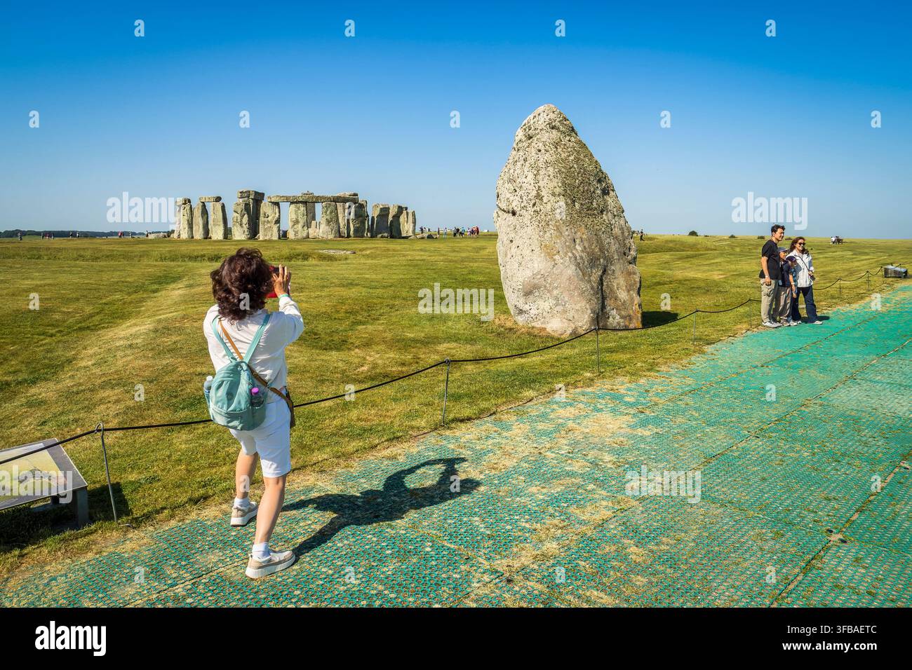 Stonehenge nel Wiltshire, il monumento preistorico più noto della Gran Bretagna, in una giornata di sole primaverile. Visitatori che posano e scattano foto. Foto Stock