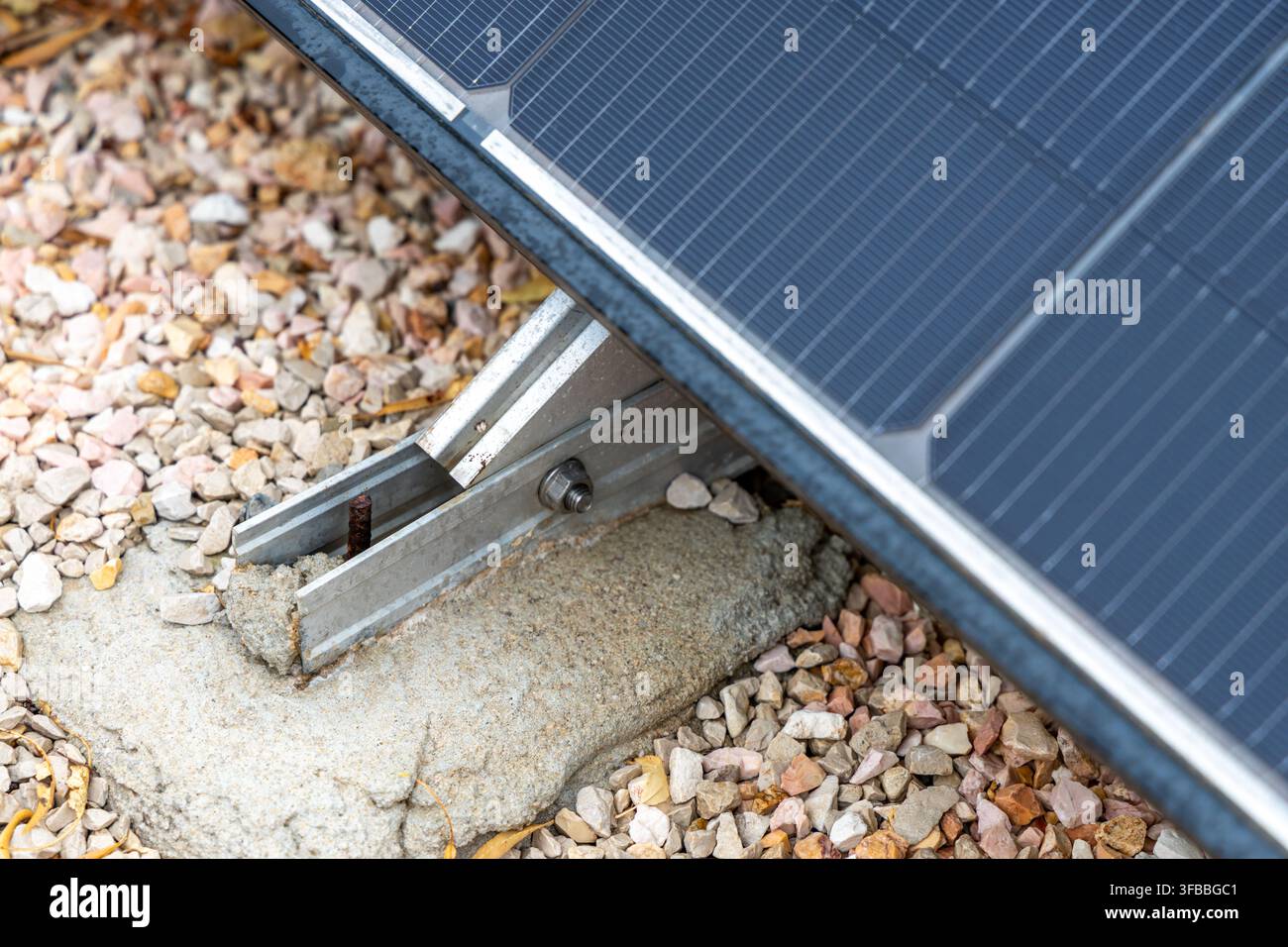 Dettaglio di una struttura di supporto per pannelli fotovoltaici che mostra la cornice metallica, la fondazione in cemento e l'aggregato circolare per la stabilità Foto Stock