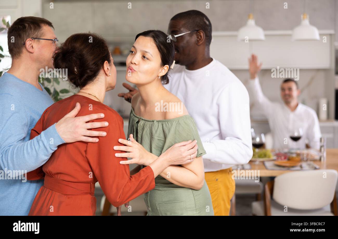Le coppie sposate si incontrano a casa per una cena di gala. Salutatevi a vicenda Foto Stock