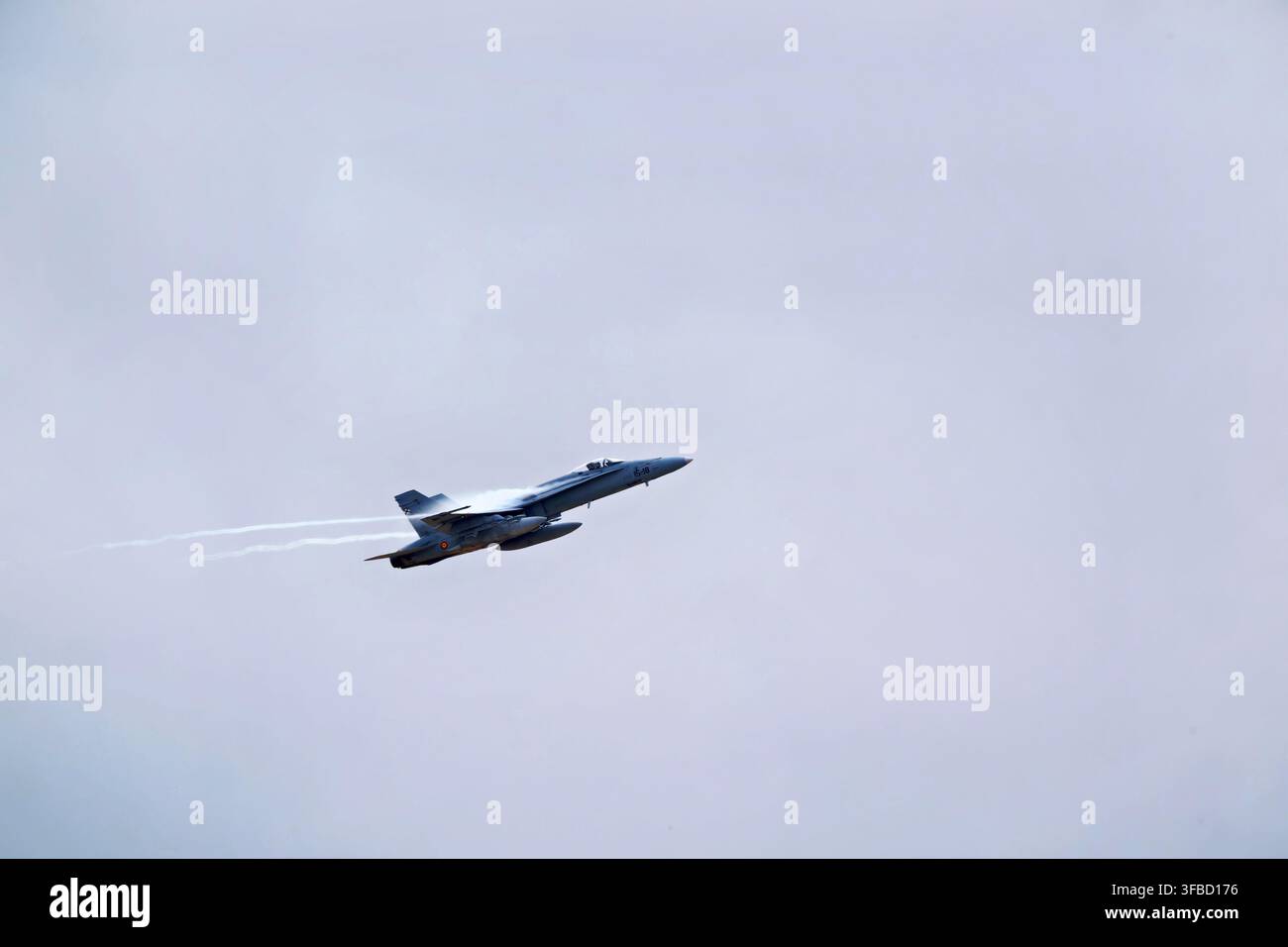 Jet militare che vola tra le nuvole nel cielo. Foto Stock