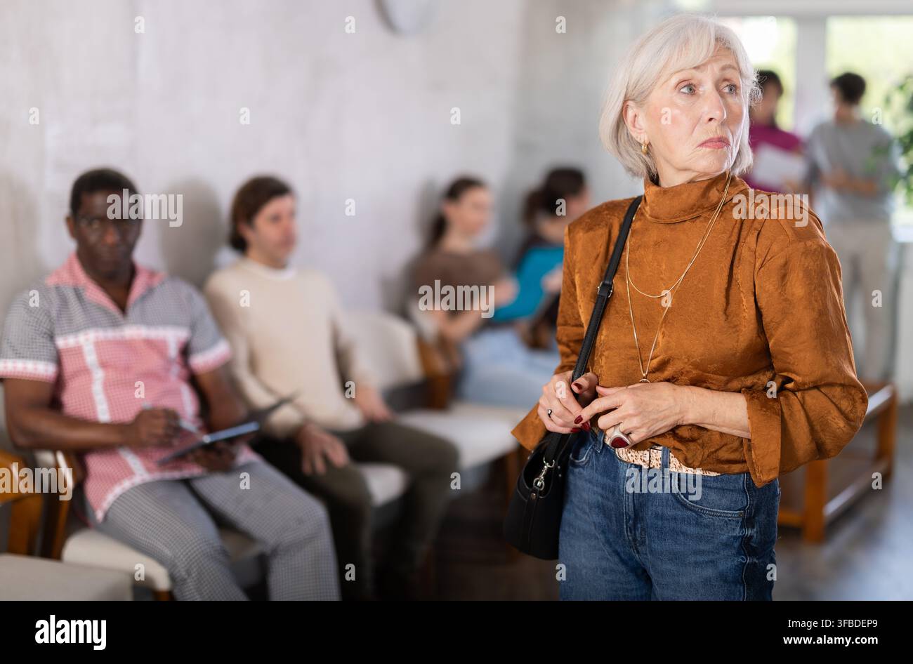 Donna matura in piedi nell'area della reception Foto Stock