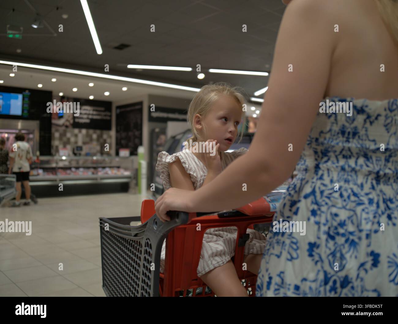 Madre e figlia con un carrello in un supermercato Foto Stock