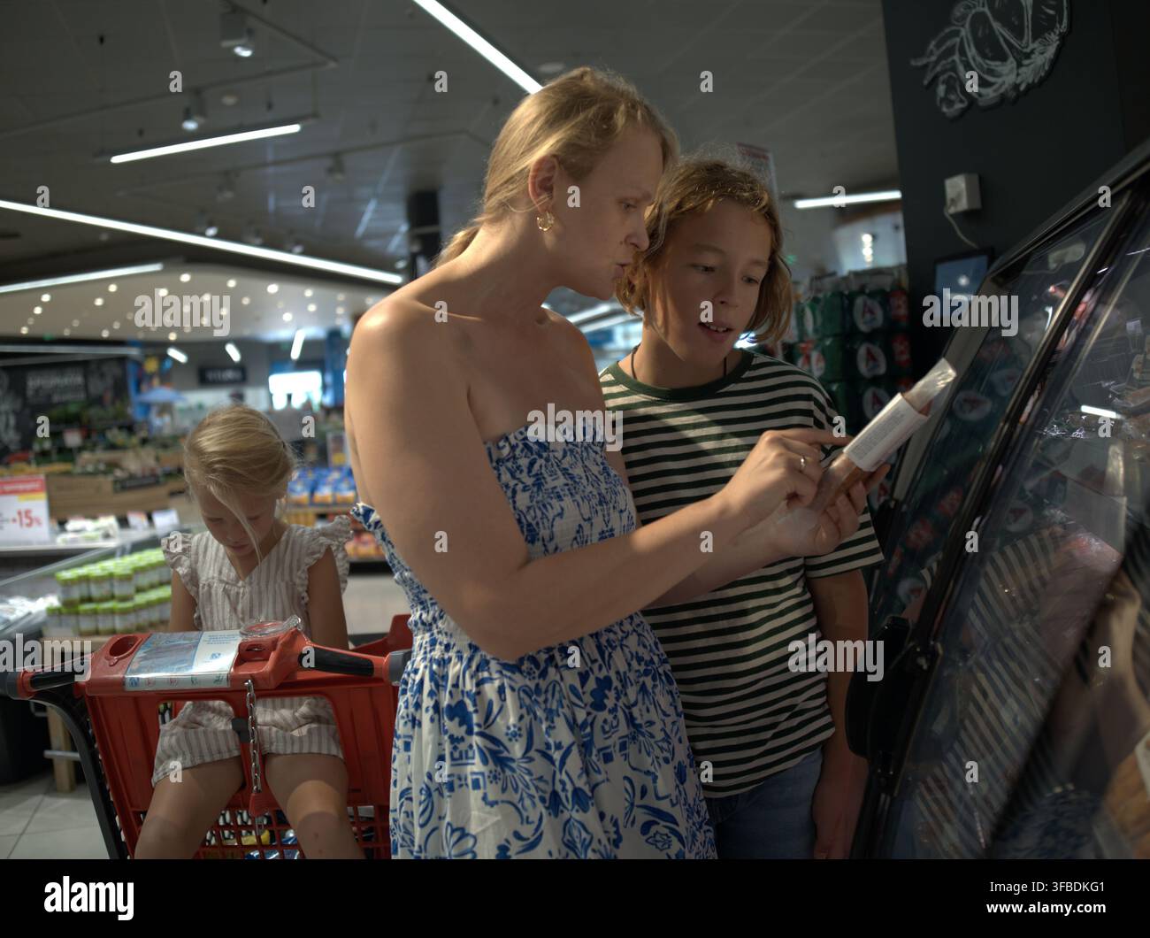 Donna e bambina che scelgono cibi surgelati in un negozio Foto Stock
