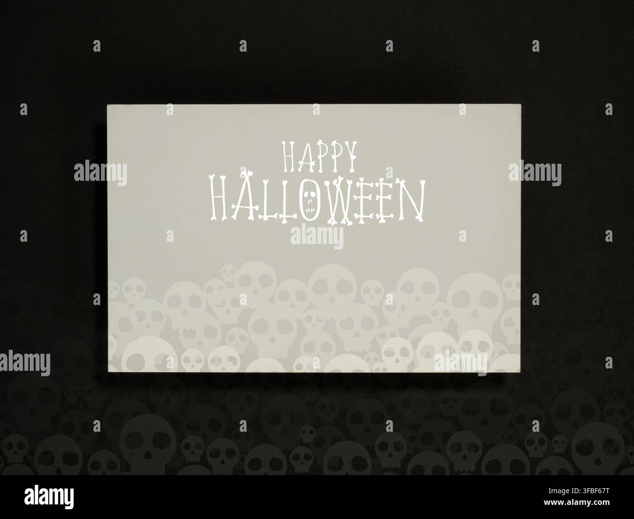 Biglietto di auguri allegro per Halloween con tipografia bianca spettrale e illustrazioni di teschi a strati su sfondo scuro. Inviti per feste, banner per eventi Foto Stock