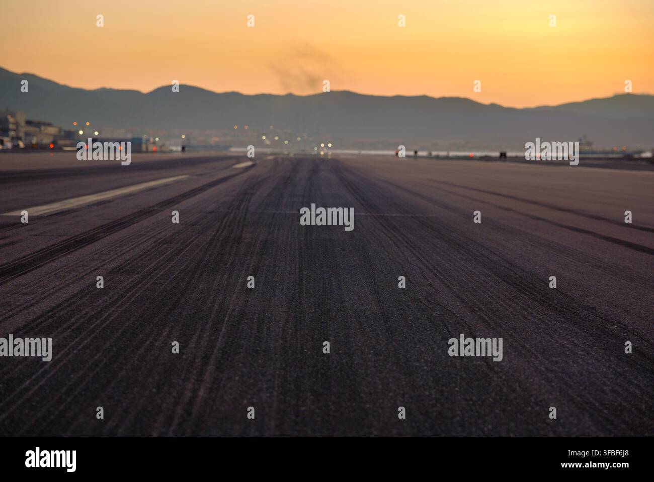 Pista di atterraggio dell'aeroporto con tracce di pneumatici al tramonto. Foto Stock