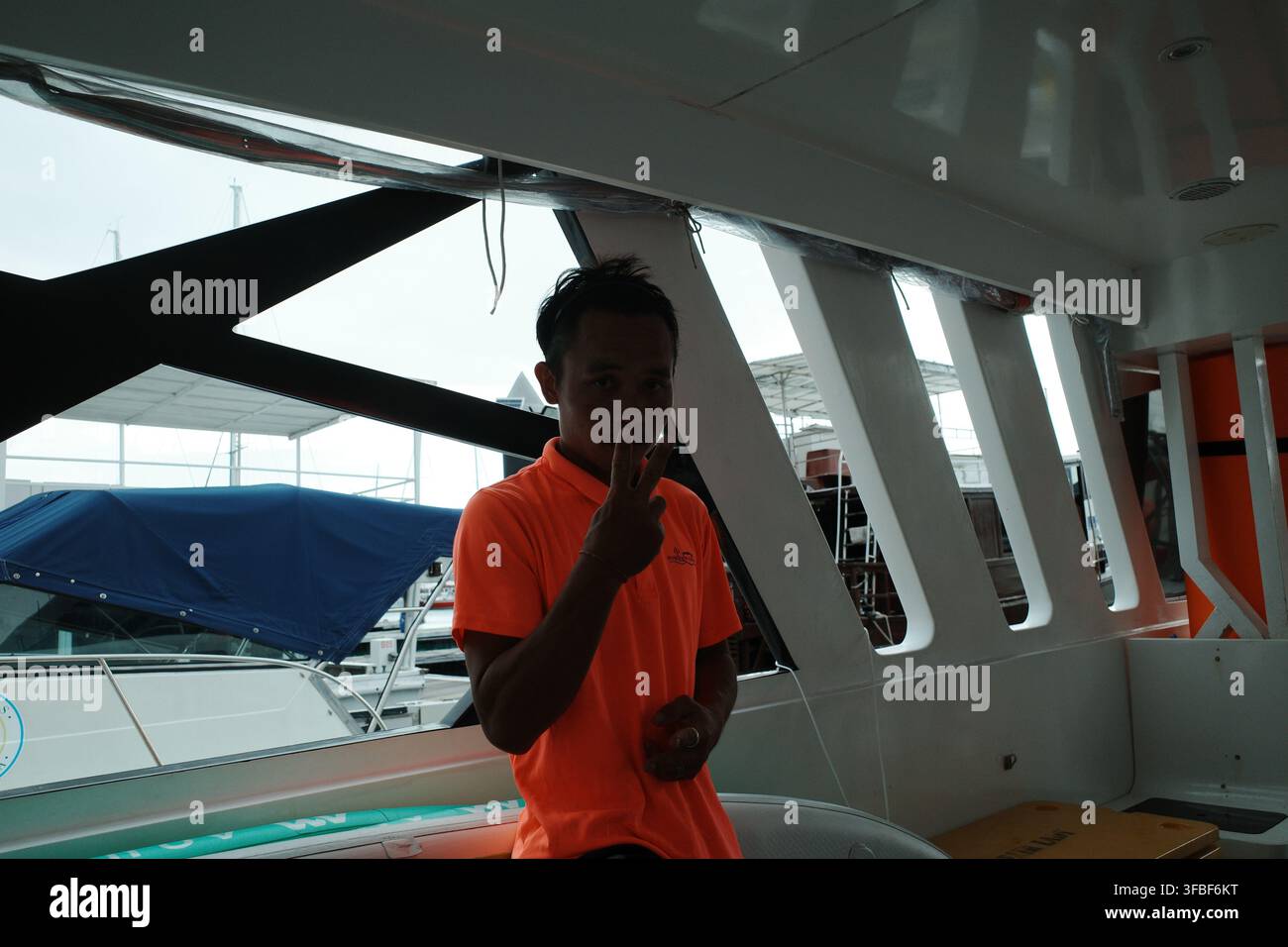 Uomo che fa il segno della pace all'interno di uno yacht Foto Stock